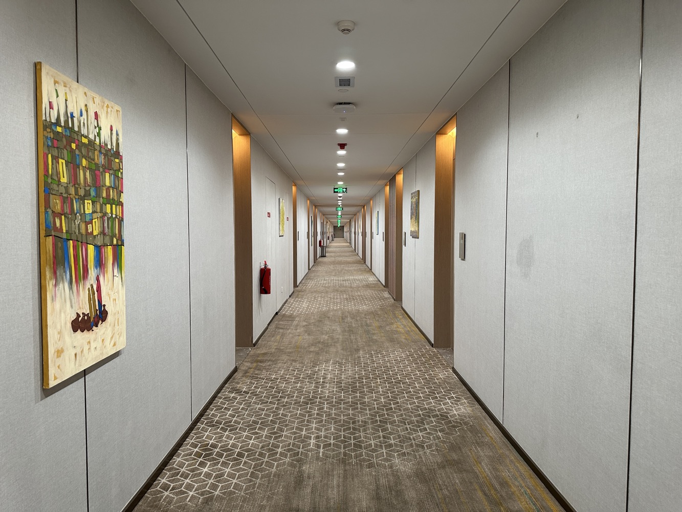 a long hallway with white walls and a painting on the wall