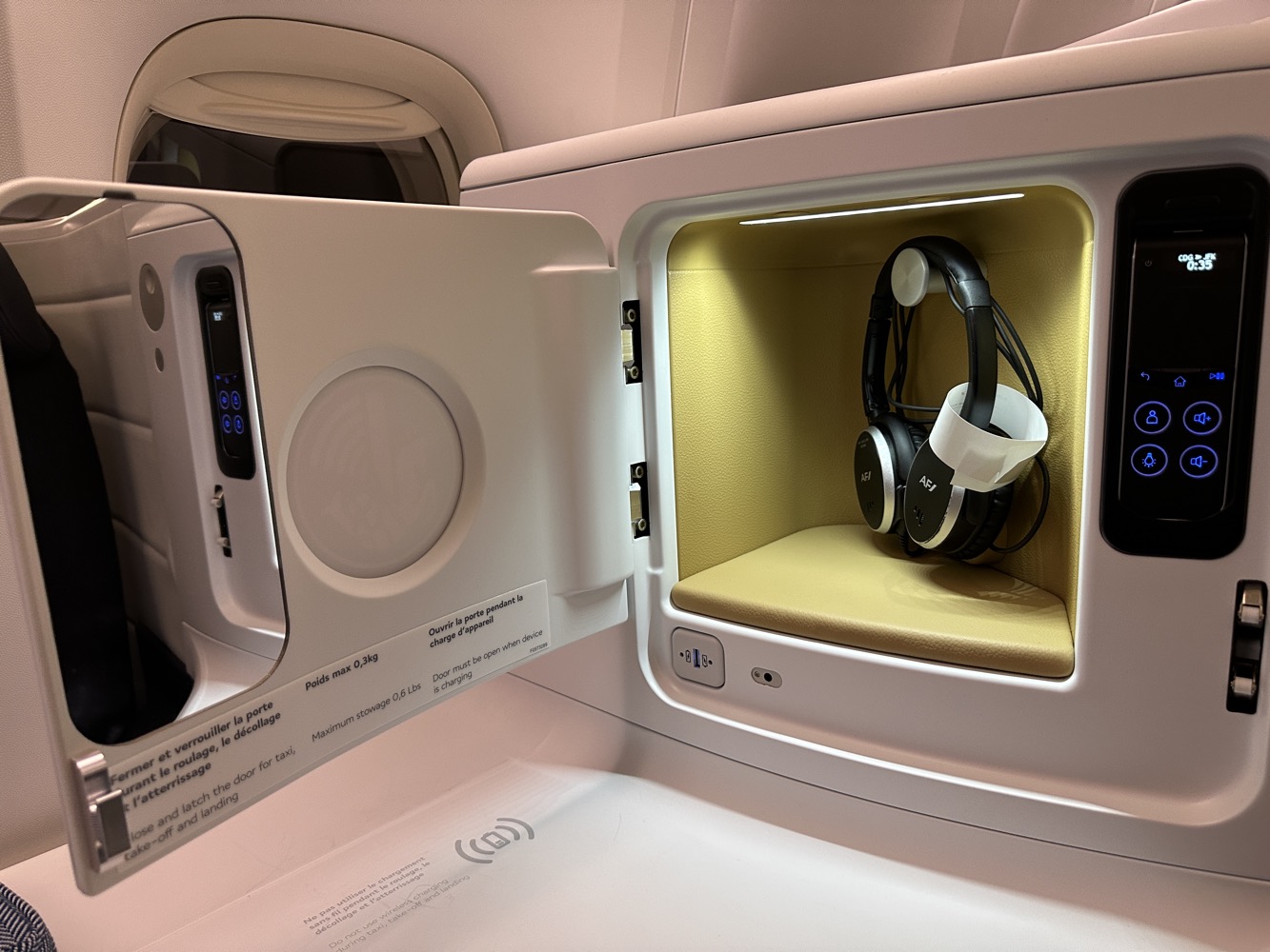a small white box with a door open and headphones inside
