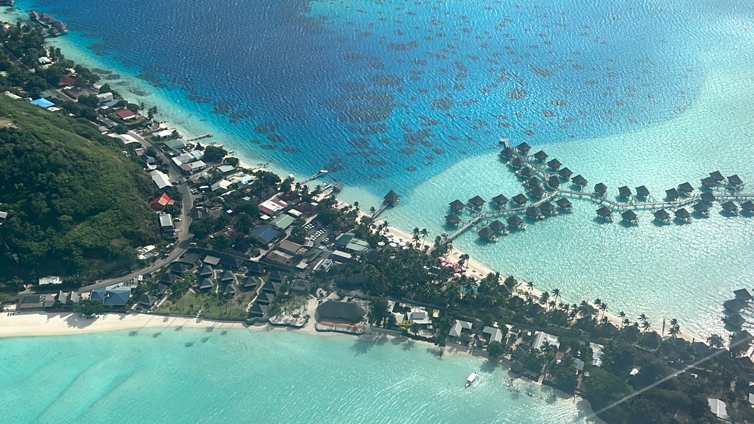 an aerial view of a beach with houses and a body of water
