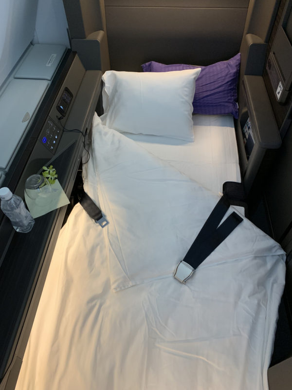 a bed with a seat belt and pillow