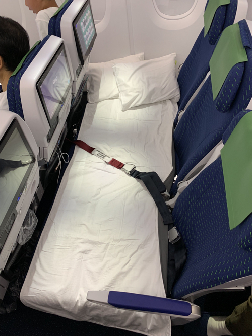 a bed with a seat belt and pillows