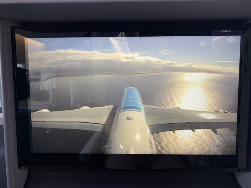 a screen with a plane flying over water