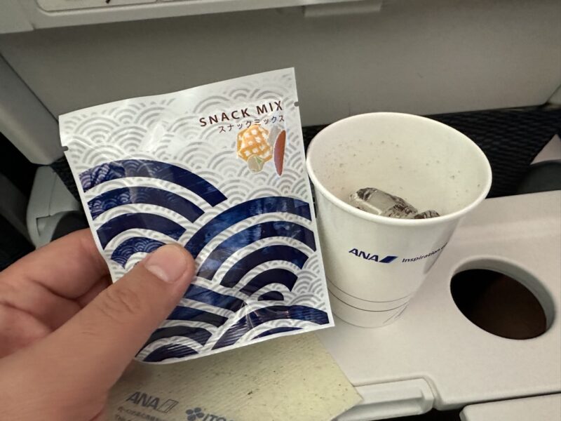 a hand holding a packet and a cup of coffee