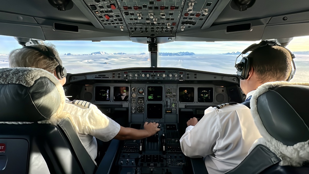 two men in white uniforms in a cockpit of an airplane