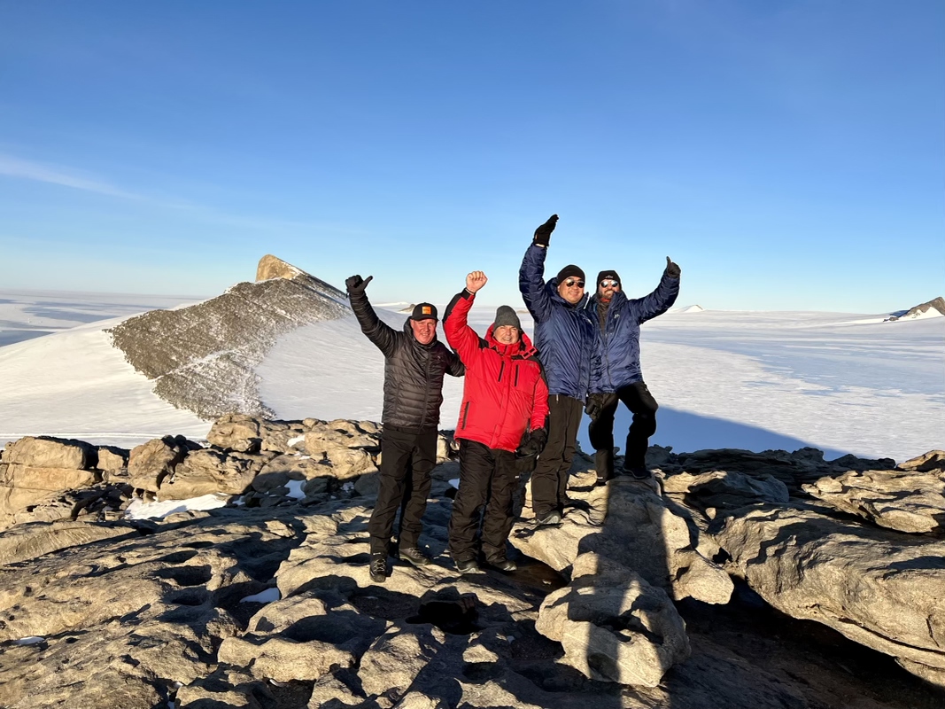a group of people standing on a rocky mountain top
