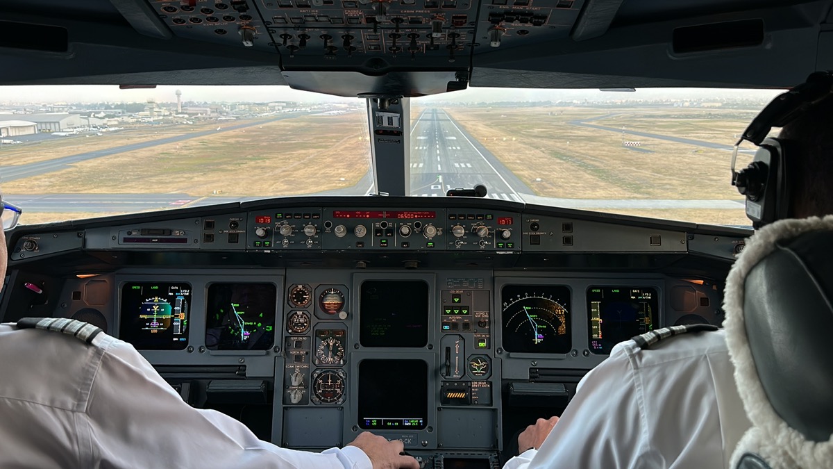 a man in a white shirt in a cockpit of an airplane