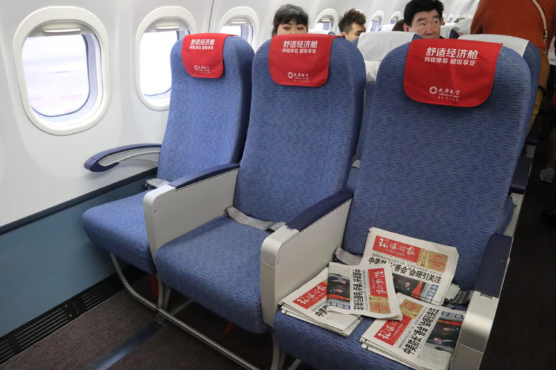 a row of blue seats with red signs on the side