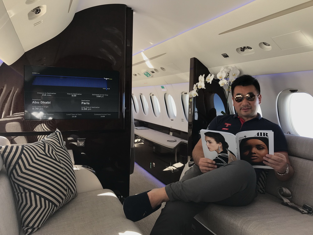 a man sitting on a couch in a plane reading a magazine