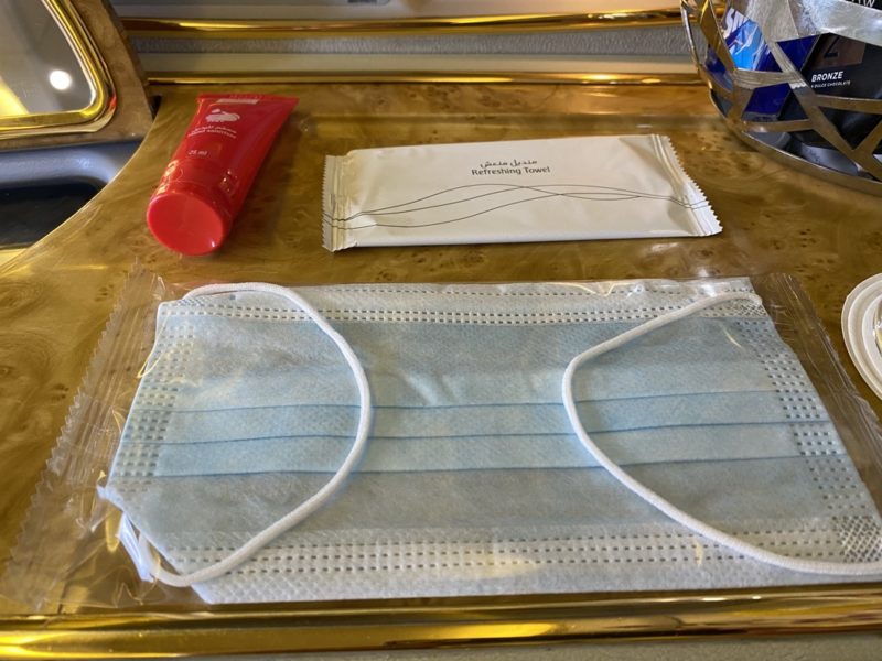 a face mask and a hand sanitizer on a tray