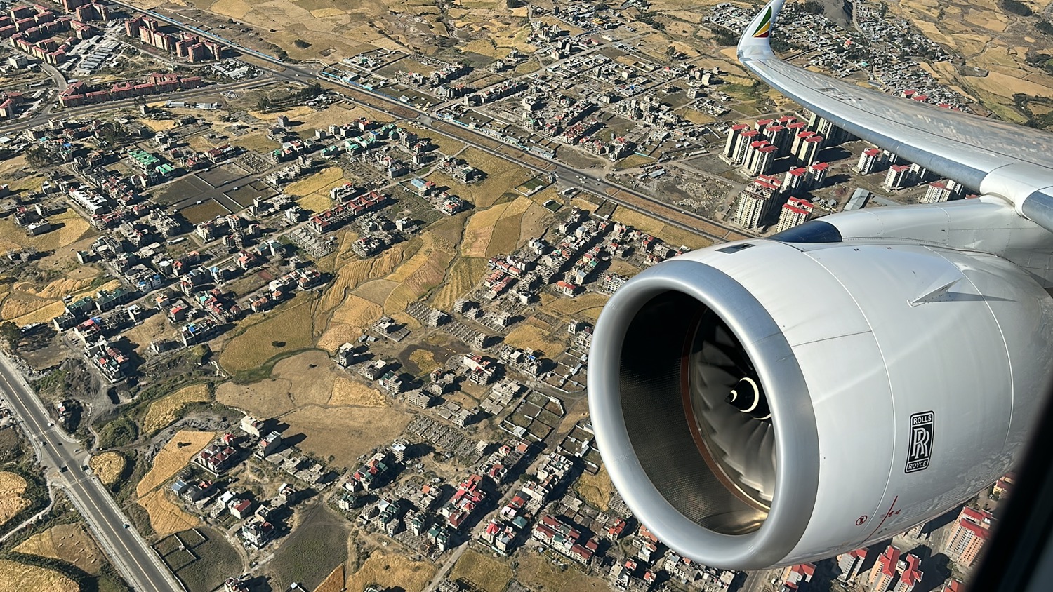 an airplane wing and engine of a city