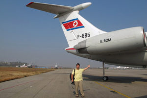 a man waving in front of an airplane