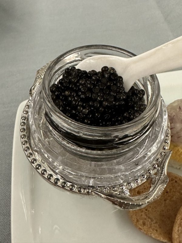 a jar of black caviar with a spoon
