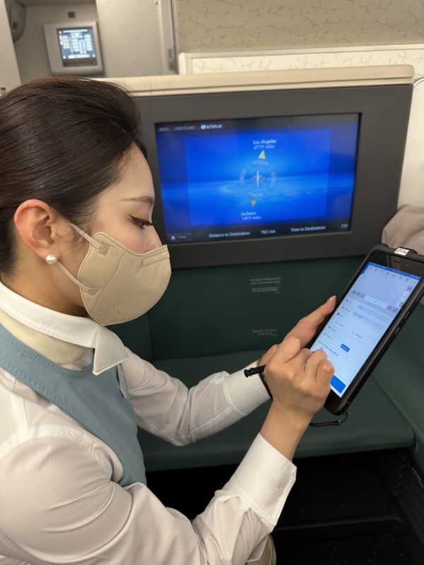 a woman wearing a mask and using a tablet