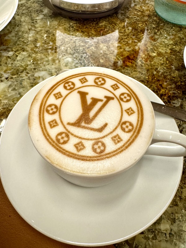 a cup of coffee with a logo on the foam