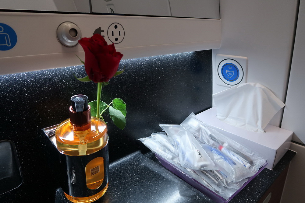 a rose in a vase next to a box of toothbrushes